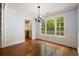 Inviting dining area featuring hardwood floors, wainscoting, and large windows with backyard views at 57 River Birch Ln., Pawleys Island, SC 29585