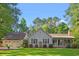Charming single-story home with a well-manicured lawn and a detached two-car garage, set amongst mature trees at 57 River Birch Ln., Pawleys Island, SC 29585