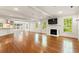 Spacious living room with hardwood floors, fireplace, and abundant natural light from multiple windows at 57 River Birch Ln., Pawleys Island, SC 29585