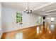 Bright living room with hardwood floors, wainscoting, and large windows overlooking the lush greenery at 57 River Birch Ln., Pawleys Island, SC 29585