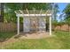 Backyard shed with double doors, pergola frame, and concrete foundation at 57 River Birch Ln., Pawleys Island, SC 29585