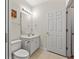 Small bathroom with a single sink vanity, toilet, tiled floors and a large entry door at 601 Hillside Dr. # 4424, North Myrtle Beach, SC 29582