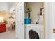 Convenient laundry area with a white washer and dryer, shelving, and a glimpse into the living and dining areas at 601 Hillside Dr. # 4424, North Myrtle Beach, SC 29582