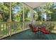 Screened-in porch with a metal table and chairs, surrounded by lush greenery and mature trees at 601 Hillside Dr. # 4424, North Myrtle Beach, SC 29582