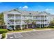 Three-story condo building with white railings, palm trees, and a parking lot at 6015 Catalina Dr. # 332, North Myrtle Beach, SC 29582