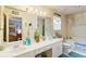 Well-lit bathroom with dual sinks, vanity, and separate tub with shower at 605 Cavandish Dr., Myrtle Beach, SC 29588