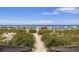 Walk down a sandy path to the beach, surrounded by lush dunes, colorful umbrellas, and the vast ocean horizon at 6803 N Ocean Blvd. # 228, Myrtle Beach, SC 29572