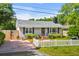 Inviting exterior featuring a picket fence, brick driveway, and cozy single-story home with a black chimney at 719 Juniper Dr., Myrtle Beach, SC 29575