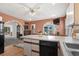 Cozy kitchen with a kitchen island with bar stool seating, white cabinets, black appliances, and hardwood floors at 719 Juniper Dr., Myrtle Beach, SC 29575