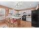 Cozy kitchen with a kitchen island with bar stool seating, white cabinets, black appliances, and hardwood floors at 719 Juniper Dr., Myrtle Beach, SC 29575
