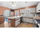 Cozy kitchen with a kitchen island with bar stool seating, white cabinets, black appliances, and hardwood floors at 719 Juniper Dr., Myrtle Beach, SC 29575