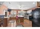 Cozy kitchen with a kitchen island with bar stool seating, white cabinets, black appliances, and hardwood floors at 719 Juniper Dr., Myrtle Beach, SC 29575