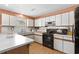 Cozy kitchen with a kitchen island with white countertops, white cabinets, and black appliances at 719 Juniper Dr., Myrtle Beach, SC 29575