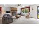 Bright living room featuring a brick fireplace, built-in shelving, and a view of the yard from a large window at 719 Juniper Dr., Myrtle Beach, SC 29575
