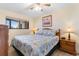 A bright bedroom featuring a large bed with a shell patterned quilt, two nightstands, and a window at 7509 N Ocean Blvd. # 404, Myrtle Beach, SC 29572