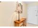 Entryway shows a wooden console table and mirror that adorns a beige wall with a white door at 7509 N Ocean Blvd. # 404, Myrtle Beach, SC 29572