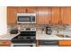 Close-up of kitchen with granite countertops, stainless steel appliances, and wooden cabinets at 7509 N Ocean Blvd. # 404, Myrtle Beach, SC 29572