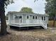 Rear exterior view of home features a porch with white railing and steps down to backyard at 803 34Th Ave. S, North Myrtle Beach, SC 29582