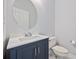 Powder room features a modern vanity, a round mirror, and a toilet at 854 Falkirk St., Myrtle Beach, SC 29579
