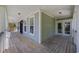 Expansive covered porch featuring wood flooring, white trim, and access to the home's interior at 854 Falkirk St., Myrtle Beach, SC 29579