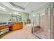 Luxurious bathroom features a glass-enclosed shower, a soaking tub, and a vanity with a makeup area at 8546 San Marcello Dr. # 1-102, Myrtle Beach, SC 29579