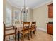 Bright dining area features tile floors, a chandelier, and a dining set with a table cloth, illuminated by natural light at 8546 San Marcello Dr. # 1-102, Myrtle Beach, SC 29579