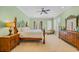 Serene bedroom with a four-poster bed, a sitting area, and lots of natural light from the windows at 8546 San Marcello Dr. # 1-102, Myrtle Beach, SC 29579