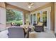 Inviting screened-in porch features comfortable wicker seating and views of the surrounding greenery at 8546 San Marcello Dr. # 1-102, Myrtle Beach, SC 29579