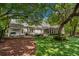Expansive backyard featuring a brick patio, outdoor seating, lush lawn, and mature trees at 9340 Lake Dr., Myrtle Beach, SC 29572