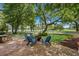 Brick patio with a firepit and Adirondack chairs overlooks a beautifully landscaped backyard at 9340 Lake Dr., Myrtle Beach, SC 29572