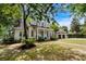 Traditional two-story home with a inviting front porch, complemented by lush landscaping and mature trees at 9340 Lake Dr., Myrtle Beach, SC 29572
