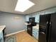 The kitchen has blue cabinets, black appliances, tile floor and a window with a sky light at 9500 Shore Dr. # 17B, Myrtle Beach, SC 29572