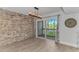Elegant dining area with modern light fixture, stone accent wall, and sliding glass doors to the outside at 9551 Edgerton Dr. # C-6, Myrtle Beach, SC 29572