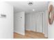Clean hallway features white trim, wood-look floors, closet, and stylish circular wall art at 9551 Edgerton Dr. # C-6, Myrtle Beach, SC 29572