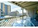 Relaxing balcony with a table and chairs showcasing a view of the pool and neighboring buildings at 9621 Shore Dr. # F-117, Myrtle Beach, SC 29572