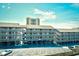 Condos with covered parking beneath and an ocean-view high-rise in the background on a sunny day at 9621 Shore Dr. # F-117, Myrtle Beach, SC 29572