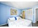 Main bedroom with blue walls, white bedding, and closet storage at 9621 Shore Dr. # F-117, Myrtle Beach, SC 29572