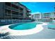 Community pool with condos in the background and blue lounge chairs available for residents at 9621 Shore Dr. # F-117, Myrtle Beach, SC 29572