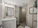 Well-lit bathroom showcasing a vanity, decorative mirror, and glass-enclosed shower, offering a refreshing ambiance at 9661 Shore Dr. # B-3, Myrtle Beach, SC 29572