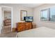 Well-lit bedroom with a TV, wooden dresser, neutral walls, and a glimpse of a living area at 9661 Shore Dr. # B-3, Myrtle Beach, SC 29572