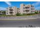 Exterior view of condominiums with balconies and tropical landscaping on a sunny day with a beautiful blue sky at 9661 Shore Dr. # B-3, Myrtle Beach, SC 29572