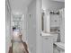 Hallway view of a well lit bathroom with white cabinet and sink and toilet at 1100 Possum Trot Rd. # D-205, North Myrtle Beach, SC 29582