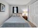 Bedroom with blue bedding, a nightstand with a lamp, and a closet with paneled doors at 1100 Possum Trot Rd. # D-205, North Myrtle Beach, SC 29582