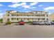 Condo building showing parking area with multiple cars and well-maintained landscaping at 1100 Possum Trot Rd. # D-205, North Myrtle Beach, SC 29582