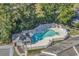 Aerial view of a kidney shaped pool with chairs, tables and white fencing at 1100 Possum Trot Rd. # D-205, North Myrtle Beach, SC 29582