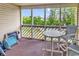 View of screened in porch with round white table and two gray chairs at 1100 Possum Trot Rd. # D-205, North Myrtle Beach, SC 29582