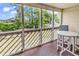 View of screened in porch with round white table and two gray chairs and view of yard at 1100 Possum Trot Rd. # D-205, North Myrtle Beach, SC 29582
