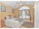 Vaulted ceiling bedroom showcases a light ceiling fan, large arched window, and neutral tones at 1206 Spinnaker Dr., North Myrtle Beach, SC 29582