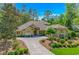 Inviting single-story home boasts lush landscaping, mature trees, and a welcoming front porch at 1206 Spinnaker Dr., North Myrtle Beach, SC 29582