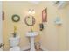 Stylish half bathroom with pedestal sink, decorative mirror, and updated fixtures at 1206 Spinnaker Dr., North Myrtle Beach, SC 29582